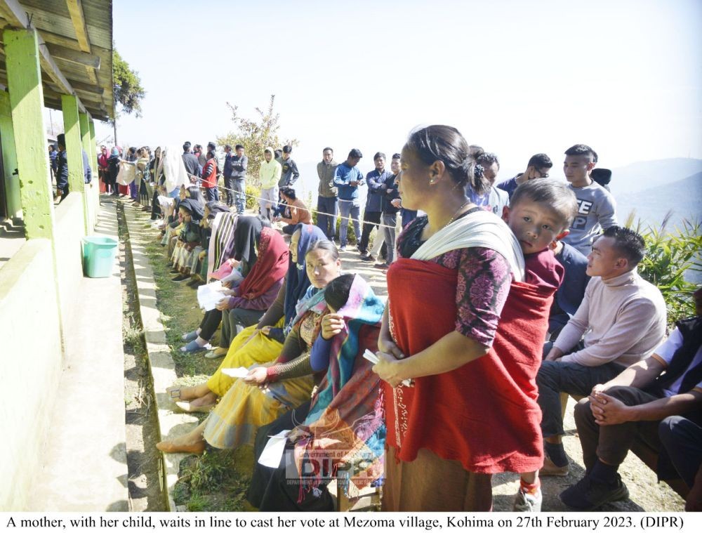 A mother with her child waits in line to cast her vote at Mezoma village, Kohima on February 27. (DIPR Photo)